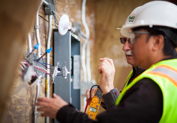 Student and teacher looking at exposed wiring