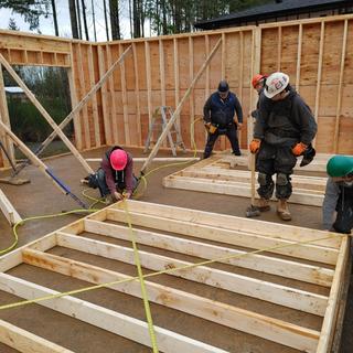 Carpentry students measuring a wall.