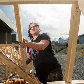 A woman checking a structure on a construction site. 