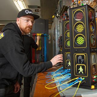 A young man working with traffic lights. 