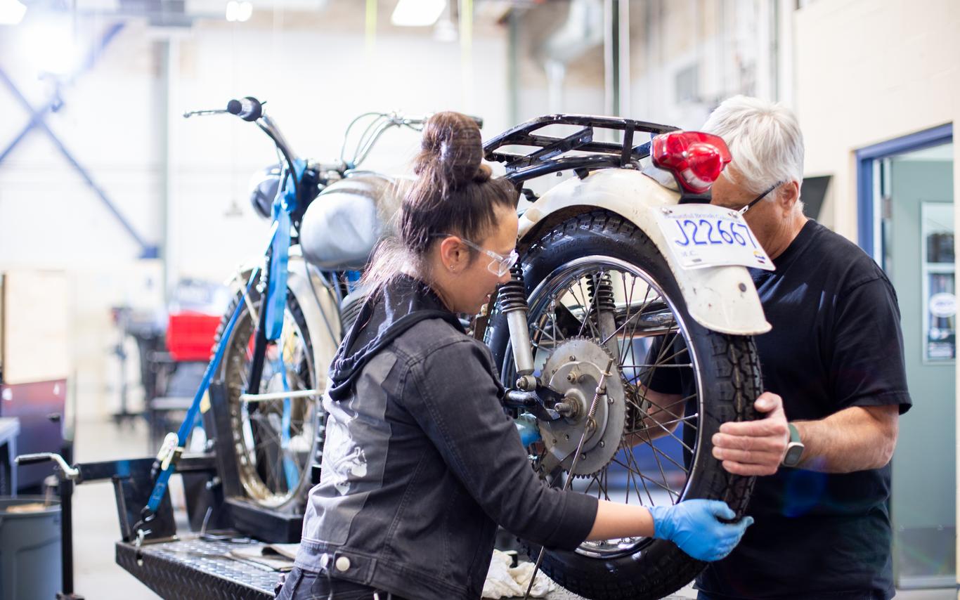 A student and instructor from the VIU Motorcycle and Marine program are working together on a motorcycle