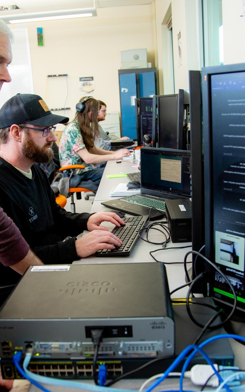 A VIU ITAS instructor helps students working on computers